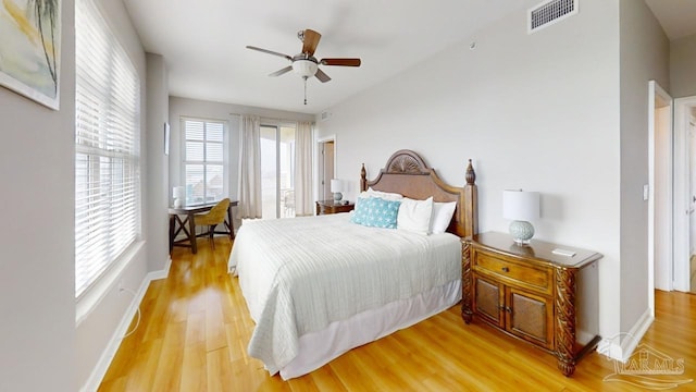 bedroom featuring ceiling fan, light wood-style flooring, visible vents, and baseboards