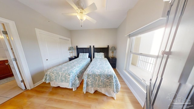 bedroom with light wood-style flooring, baseboards, ceiling fan, and a closet