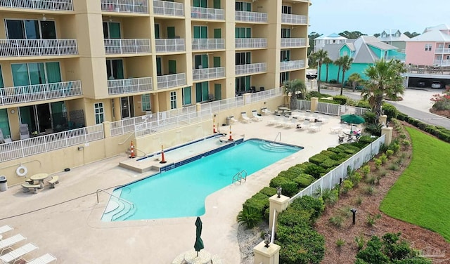 pool with a patio and fence