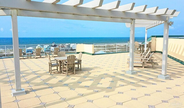 view of patio featuring outdoor dining area, a water view, and a pergola