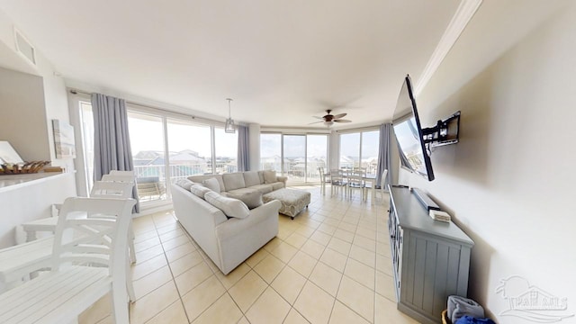 living area with light tile patterned floors, visible vents, ceiling fan, a wall of windows, and crown molding