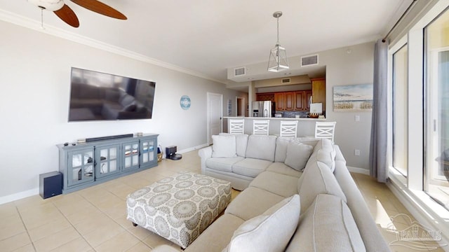 living room featuring light tile patterned floors, ornamental molding, visible vents, and baseboards