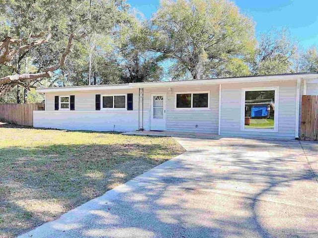 6562 Julia Dr, Milton, FL 32570 - ranch-style house featuring fence, driveway, and a front lawn