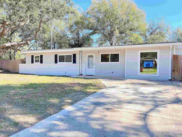 ranch-style house featuring fence, driveway, and a front lawn