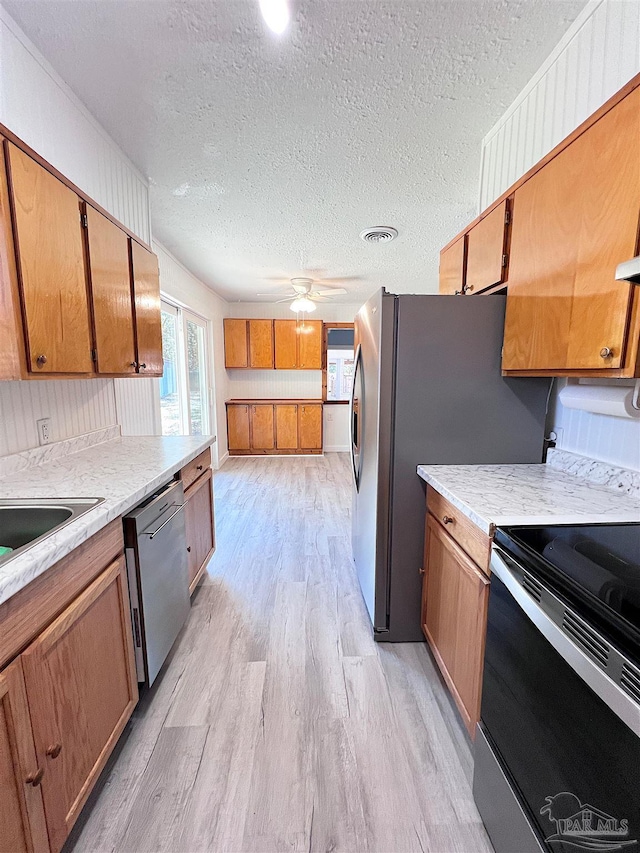 kitchen with electric stove, light wood finished floors, light countertops, visible vents, and stainless steel dishwasher