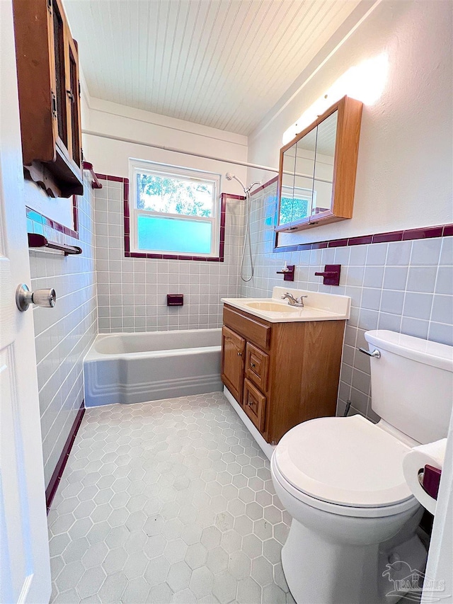 full bathroom with toilet, shower / bath combination, tile walls, and vanity