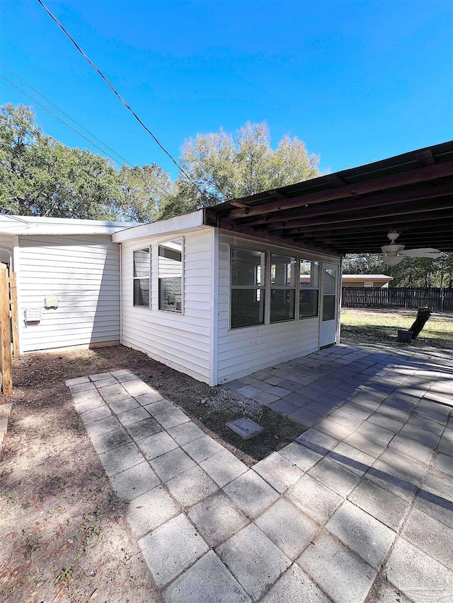 view of home's exterior featuring a patio area, fence, a carport, and concrete driveway