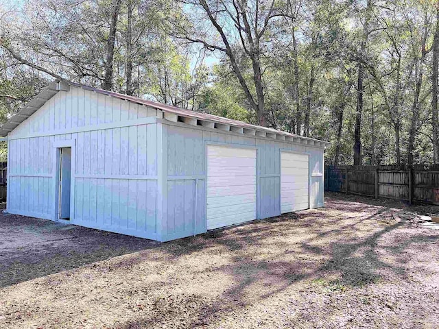 detached garage featuring fence