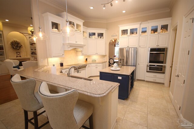 kitchen featuring backsplash, white cabinetry, stainless steel appliances, and a sink
