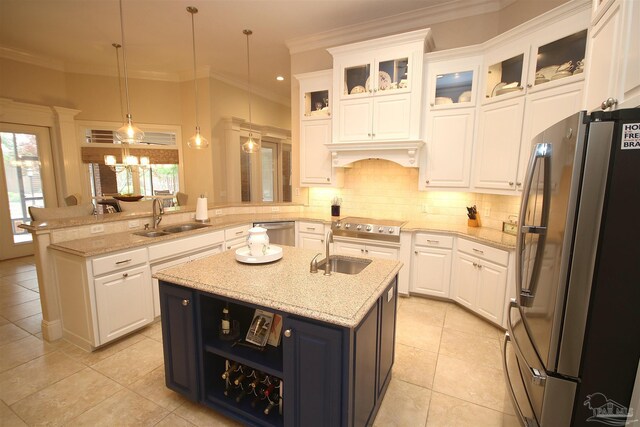 kitchen with a peninsula, appliances with stainless steel finishes, a sink, and white cabinetry