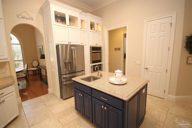kitchen with a sink, white cabinetry, crown molding, an island with sink, and appliances with stainless steel finishes