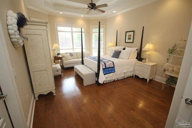 bedroom featuring ornamental molding, a tray ceiling, baseboards, dark wood-style flooring, and recessed lighting