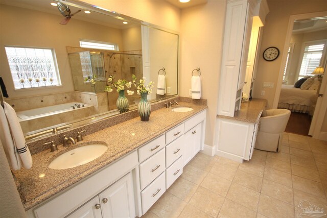 bathroom featuring tile patterned flooring, a sink, double vanity, and a stall shower