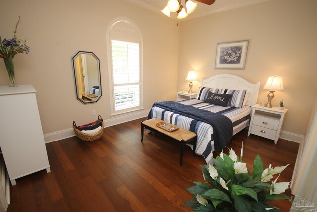 bedroom with baseboards, wood finished floors, and crown molding