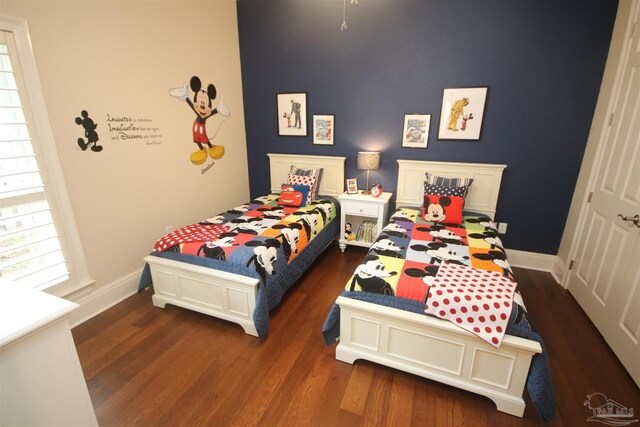 bedroom with baseboards and wood finished floors