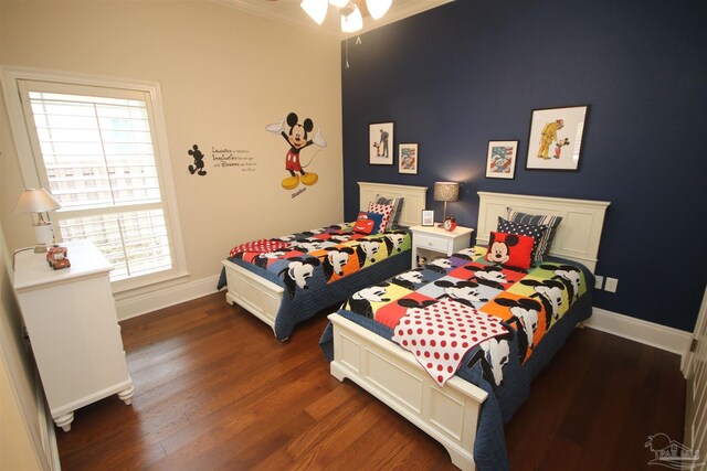 bedroom featuring baseboards, ornamental molding, and wood finished floors