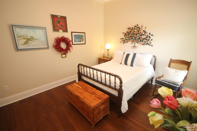 bedroom with wood finished floors and baseboards