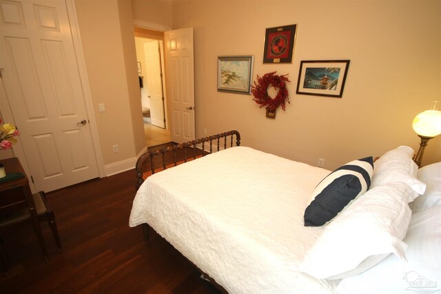 bedroom featuring baseboards and dark wood-style floors