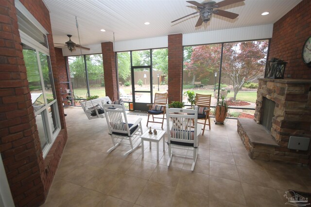 sunroom / solarium with an outdoor living space with a fireplace and ceiling fan