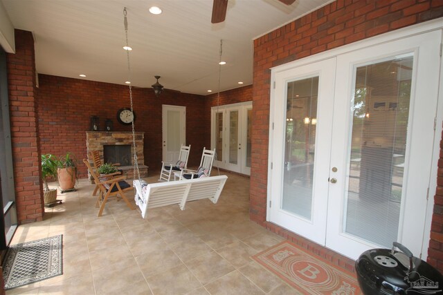 view of patio / terrace with an outdoor stone fireplace, a ceiling fan, french doors, and visible vents
