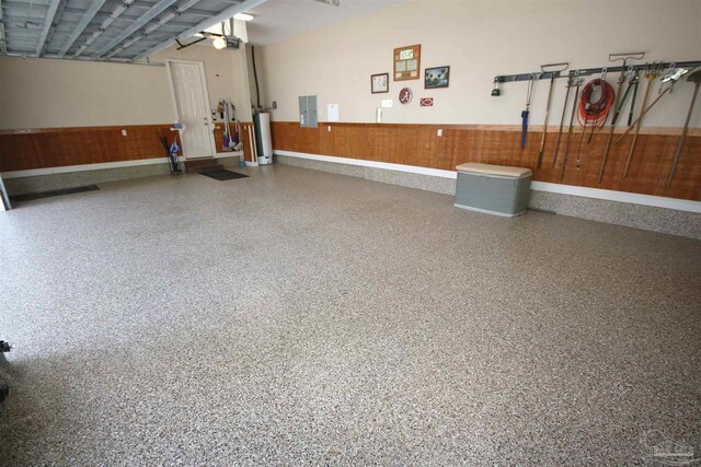 garage with electric panel, gas water heater, and a garage door opener