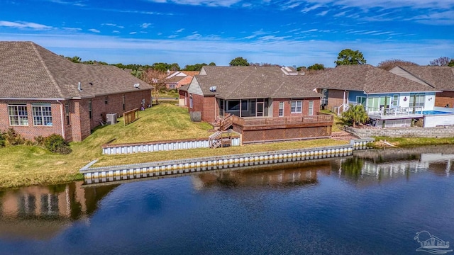 back of house with a lawn, cooling unit, and a water view