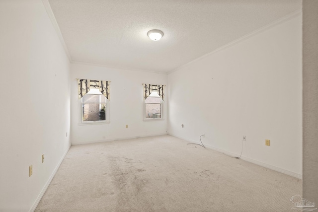 carpeted empty room featuring ornamental molding and a textured ceiling