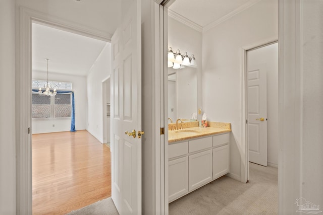 bathroom with vanity, an inviting chandelier, and crown molding