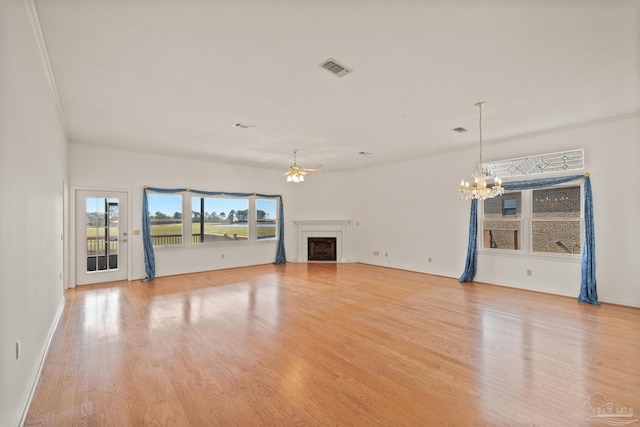 unfurnished living room featuring light hardwood / wood-style floors, crown molding, and ceiling fan with notable chandelier