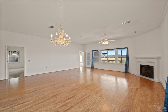 unfurnished living room featuring ceiling fan with notable chandelier, a fireplace, and light hardwood / wood-style flooring