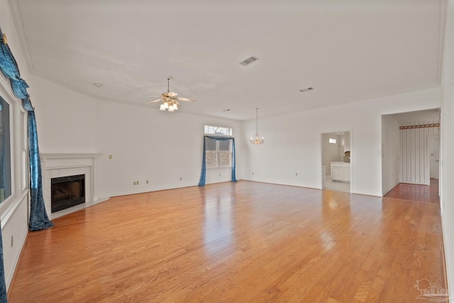 unfurnished living room featuring light wood-type flooring and ceiling fan with notable chandelier