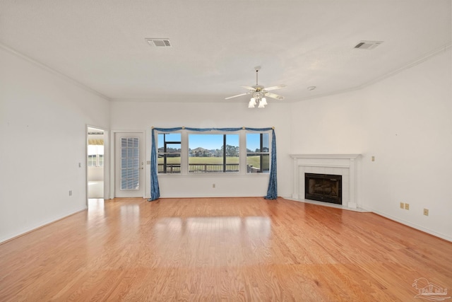 unfurnished living room featuring ceiling fan, light hardwood / wood-style floors, and crown molding