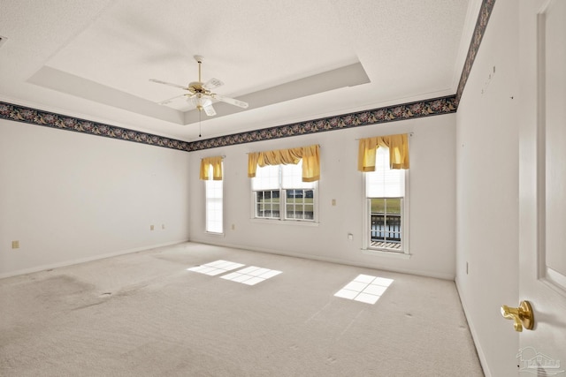 carpeted spare room with a raised ceiling, a textured ceiling, and ceiling fan