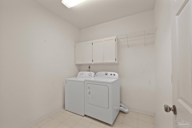 laundry room featuring a textured ceiling, cabinets, and separate washer and dryer