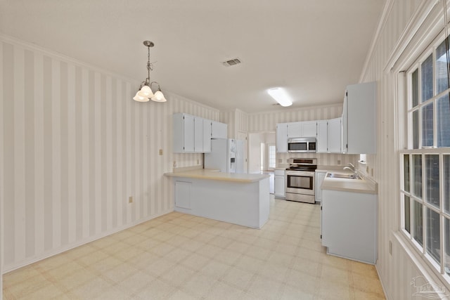 kitchen featuring stainless steel appliances, sink, decorative light fixtures, kitchen peninsula, and crown molding