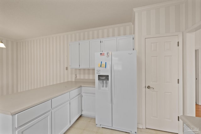 kitchen featuring white cabinets, white refrigerator with ice dispenser, and ornamental molding