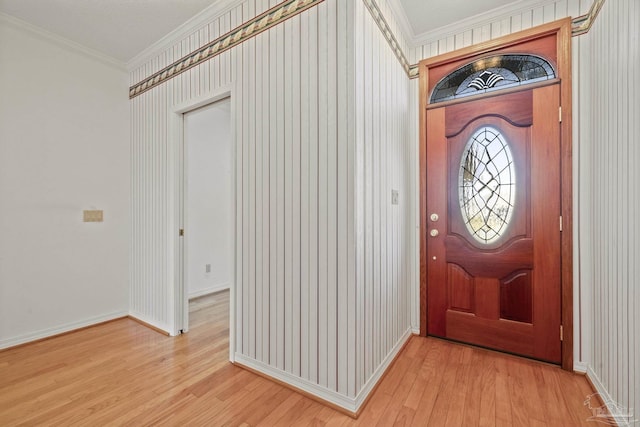 foyer with ornamental molding and light hardwood / wood-style floors