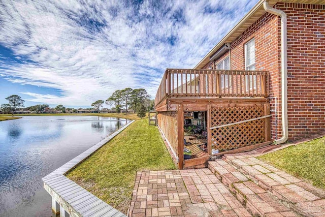 exterior space with a lawn and a deck with water view