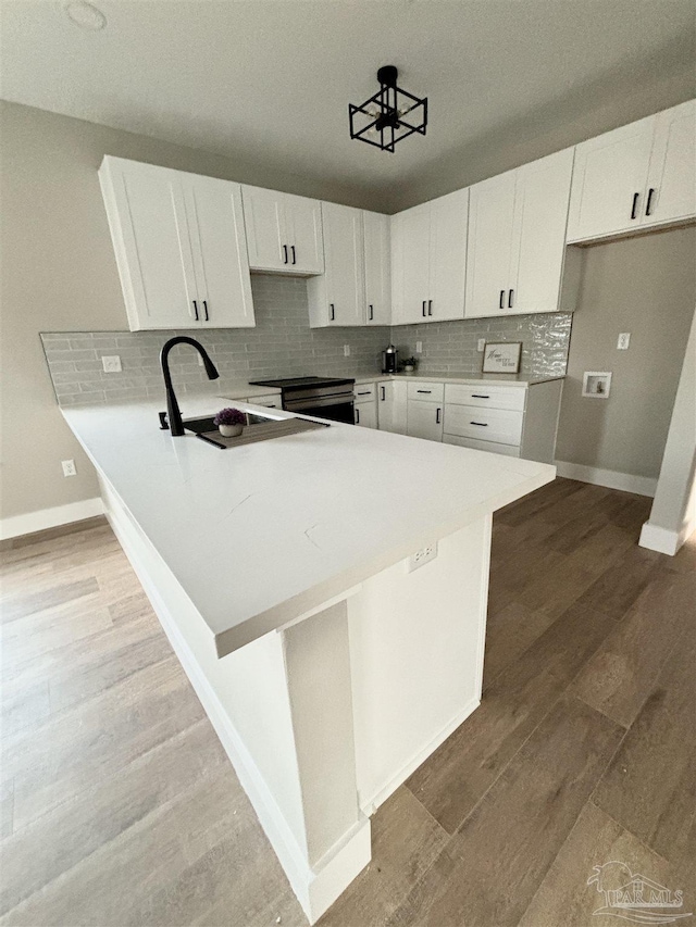 kitchen featuring light hardwood / wood-style flooring, white cabinets, and kitchen peninsula