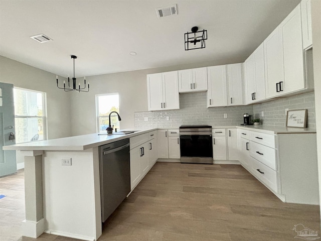 kitchen featuring range, hanging light fixtures, dishwasher, kitchen peninsula, and white cabinets