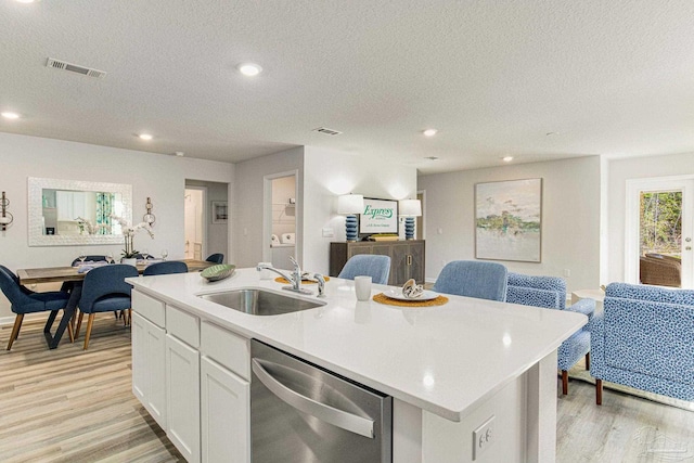 kitchen with dishwasher, a center island with sink, white cabinetry, and sink