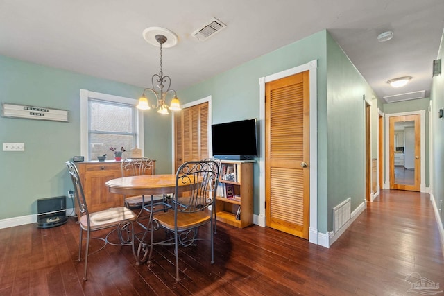 dining room featuring dark hardwood / wood-style flooring and a chandelier