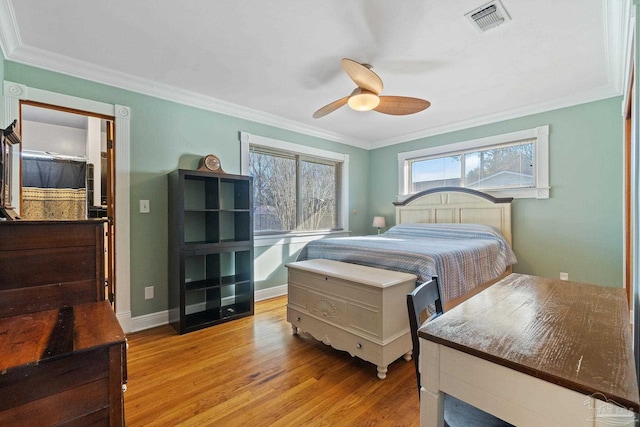 bedroom with light wood-type flooring, ceiling fan, and ornamental molding