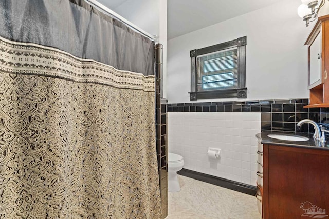 bathroom featuring tile patterned floors, tile walls, toilet, and vanity