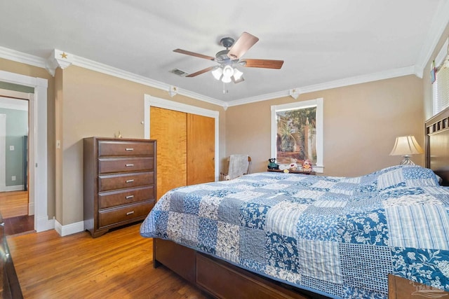 bedroom with ceiling fan, a closet, ornamental molding, and hardwood / wood-style floors