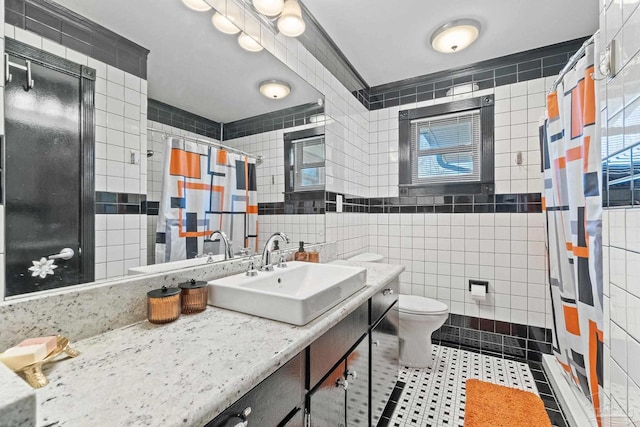 bathroom with toilet, a shower with shower curtain, tile walls, tile patterned floors, and vanity