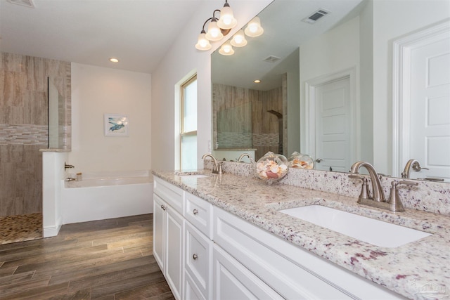 bathroom with hardwood / wood-style floors, shower with separate bathtub, and vanity