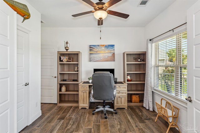 home office featuring a wealth of natural light, ceiling fan, and dark hardwood / wood-style floors