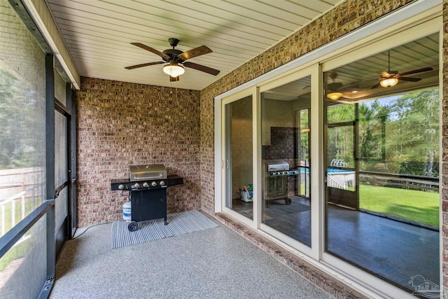 unfurnished sunroom featuring wood ceiling and ceiling fan