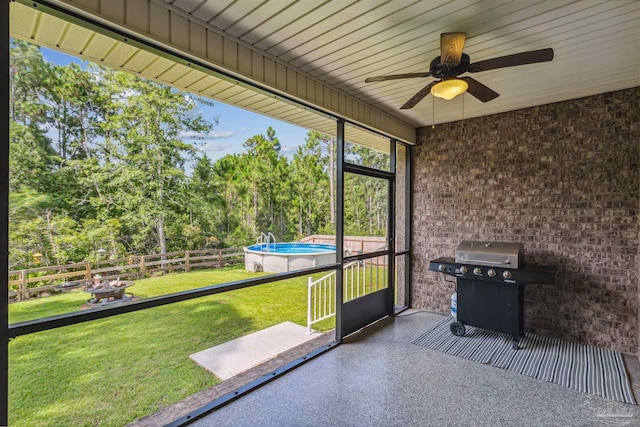 unfurnished sunroom featuring ceiling fan